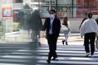 People walk near an electronic stock board showing Japan's Nikkei 225 index at a securities firm Wednesday, March 27, 2024, in Tokyo. Asian shares were mixed on Wednesday after Wall Street slipped a bit further from its record highs.(AP Photo/Eugene Hoshiko)