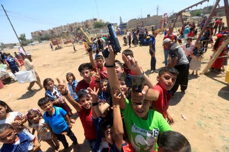 Iraqi children play as they celebrate Eid al-Fitr, in Mosul, Iraq June 25, 2017. REUTERS/Alaa Al-Marjani