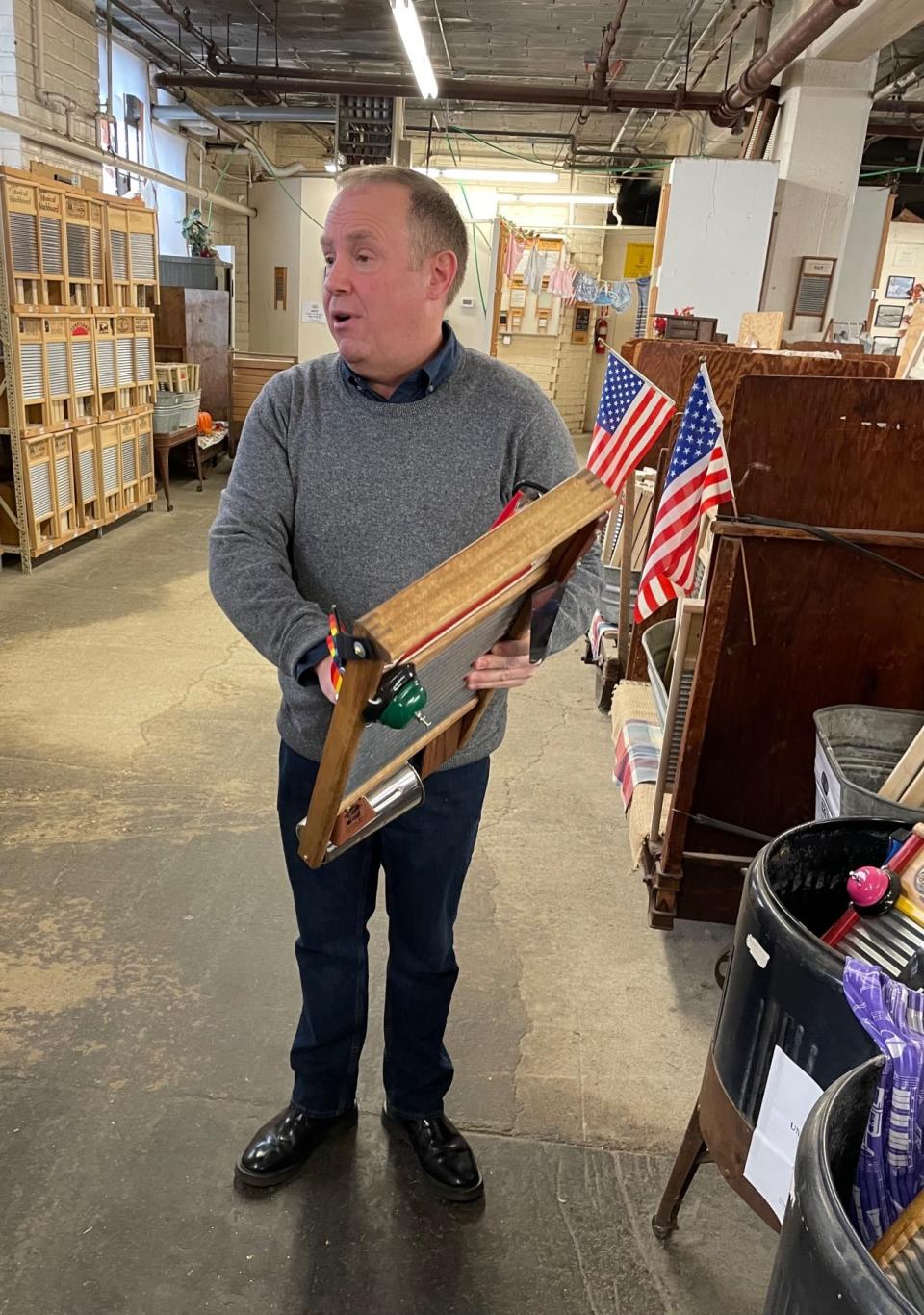 Martin demonstrates a musical washboard during a factory tour.