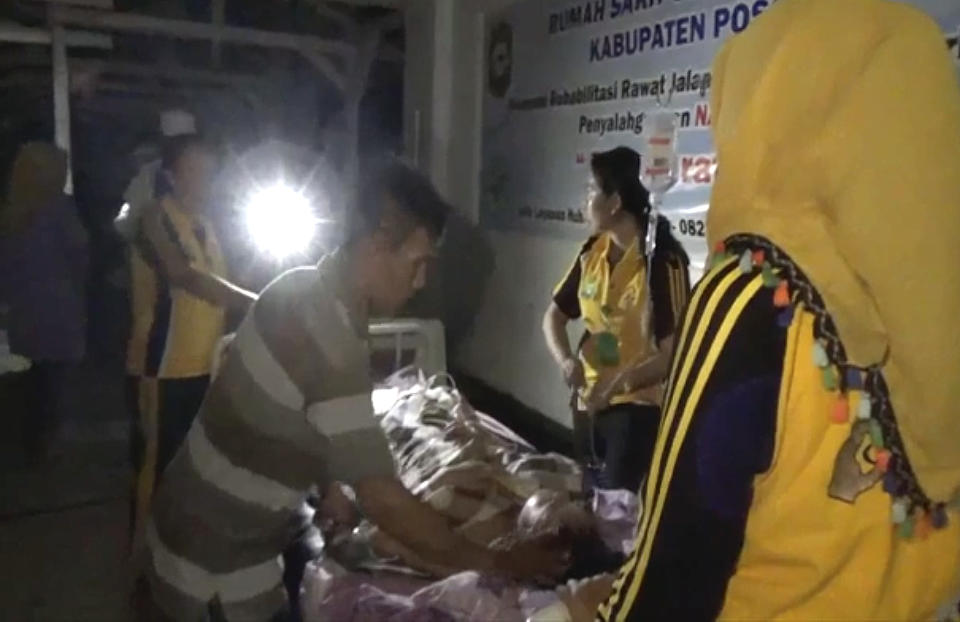 In this image made from video, patients are evacuated from a hospital following a strong earthquake in Poso, central Sulawesi, Indonesia, Friday, Sept. 28, 2018. A powerful earthquake has rocked the Indonesian island of Sulawesi and triggered a 1.5-meter (5-foot) tsunami that swept away houses in at least two cities. (AP Photo)