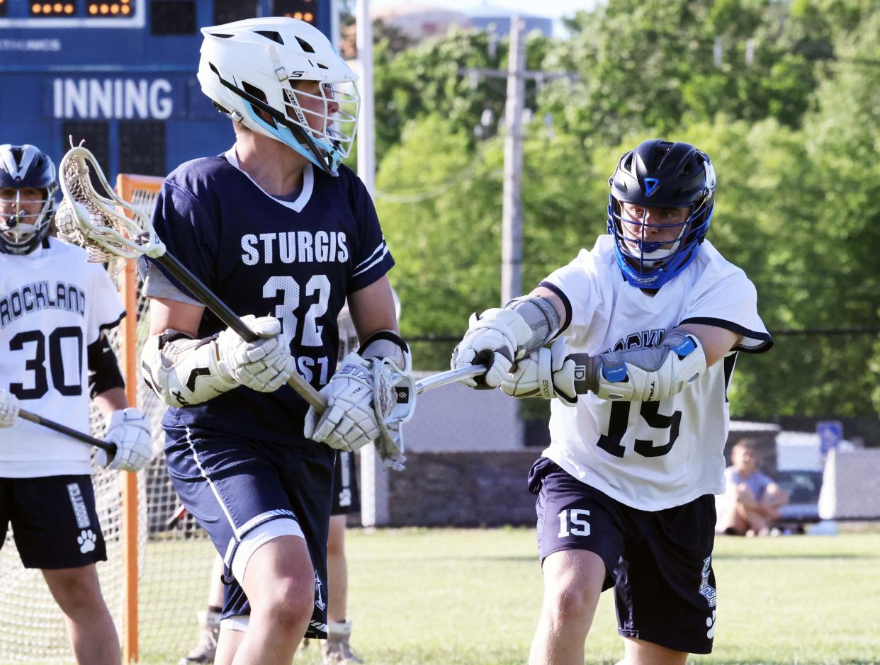 Rockland defender Joe Earner stick checks Sturgis East forward Hogan Anderson during a game on Thursday, June 9, 2022.