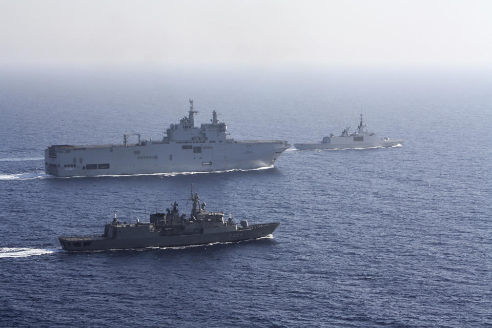 In this photo provided by the Greek National Defence, a French Tonnerre helicopter carrier, rear left is escorted by Greek and French military vessels during a maritime exercise in the Eastern Mediterranean, Thursday, Aug. 13, 2020. Greece's prime minister warmly thanked France for its decision to boost its military presence in the eastern Mediterranean, where Greek and Turkish warships are closely shadowing each other over a Turkish energy exploration bid in waters Athens claims as its own. (Greek National Defence via AP)