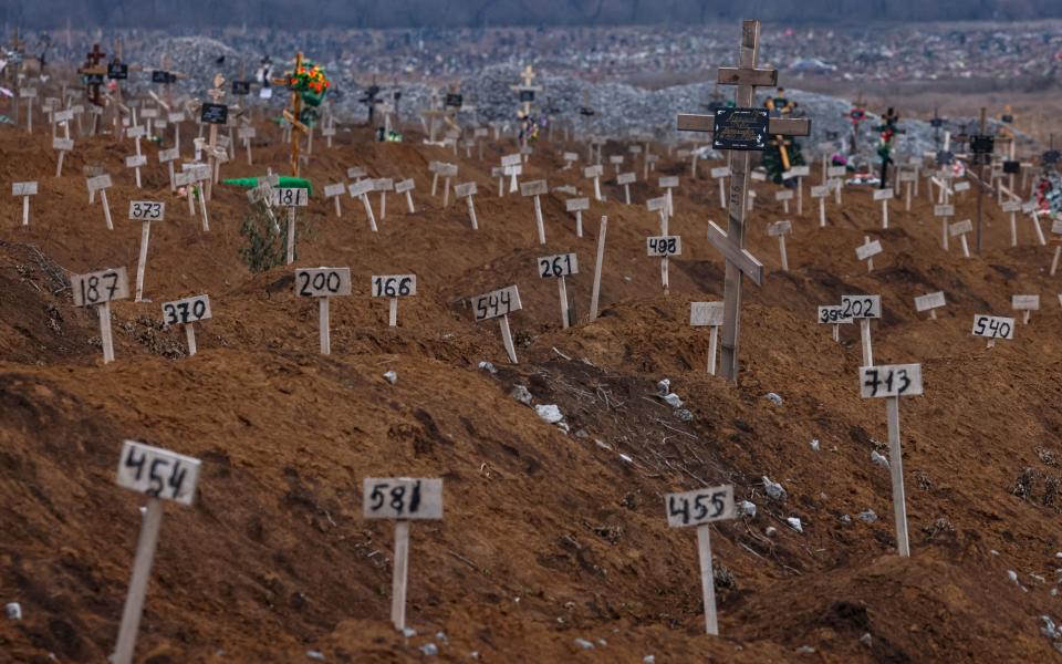 Numbers mark the graves of unidentified local residents who were killed during fighting in Mariupol, Ukraine - SERGEI ILNITSKY/EPA-EFE/Shutterstock 
