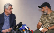 FILE - In this file photo taken on Sunday, April 22, 2018, Former Armenian President Serzh Sargsyan, left, speaks with protest leader Nikol Pashinian during their meeting in Yerevan, Armenia. Armenians are set to cast ballots in parliamentary elections expected to cement the incumbent prime minister's grip on power. (Hrant Khachatryan/PAN Photo via AP, File)