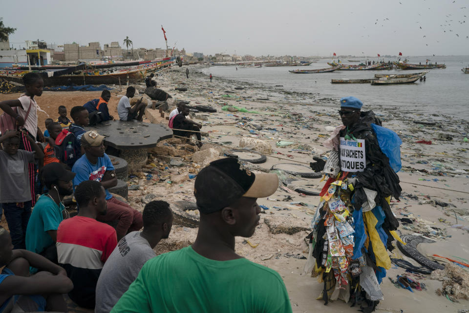 FILE - The environmental activist Modou Fall, who many simply call "Plastic Man", talks to the locals about the pollution caused by plastic bags at the Yarakh Beach littered by trash in Dakar, Senegal, Tuesday, Nov. 8, 2022. Negotiators from around the world gather at UNESCO in Paris on Monday, May 29, 2023, for a second round of talks aiming toward a global treaty on fighting plastic pollution in 2024. (AP Photo/Leo Correa, File)