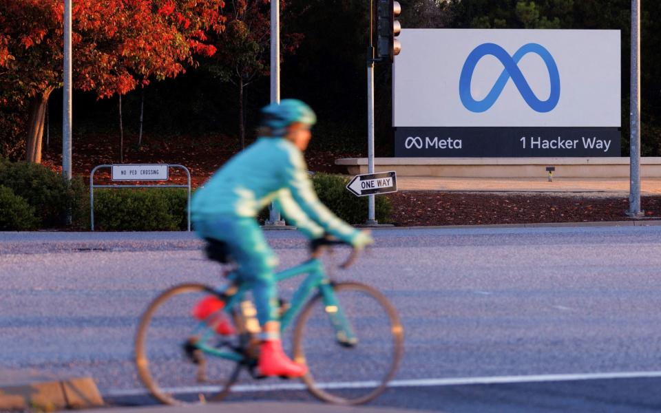 A cyclist rides past the Meta sign outside the headquarters of Facebook's parent company in Mountain View, California - REUTERS/Peter DaSilva