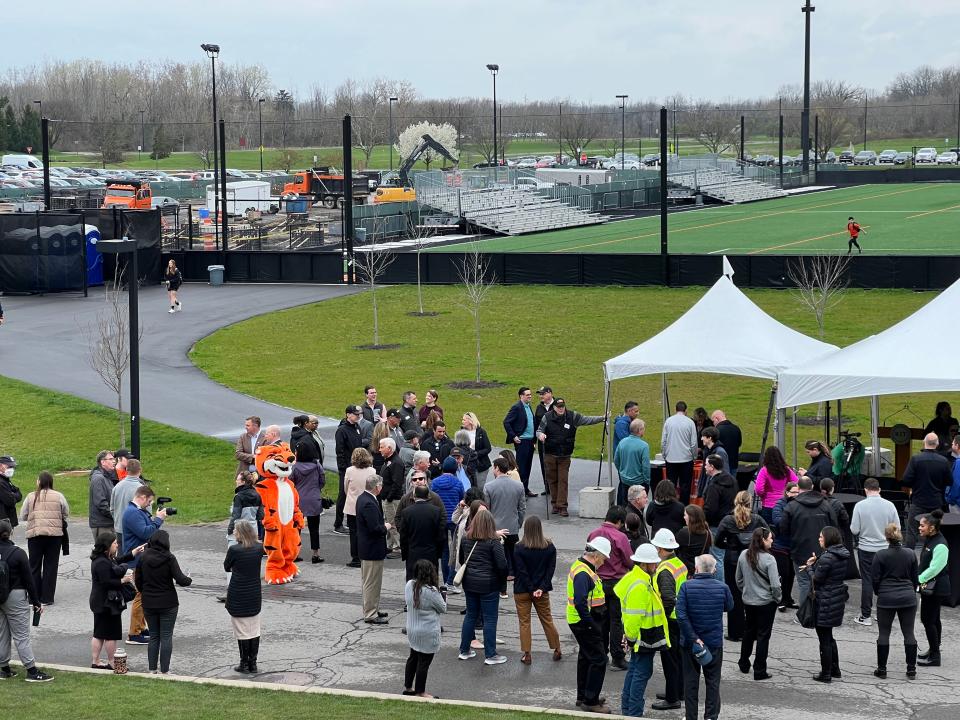 People gathered near the construction site of Rochester Institute of Technology's new Tiger Stadium on Thursday, April 18, 2024, for a ceremonial groundbreaking. The 38,828-square-foot stadium is going up on the west side of the field and will house soccer and lacrosse.