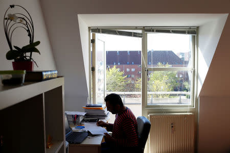 Hussein, 36, originally from Pakistan, studies for his PhD in his apartment in Mjolnerparken, a housing estate that features on the Danish government's "Ghetto List", in Copenhagen, Denmark, May 8, 2018. REUTERS/Andrew Kelly