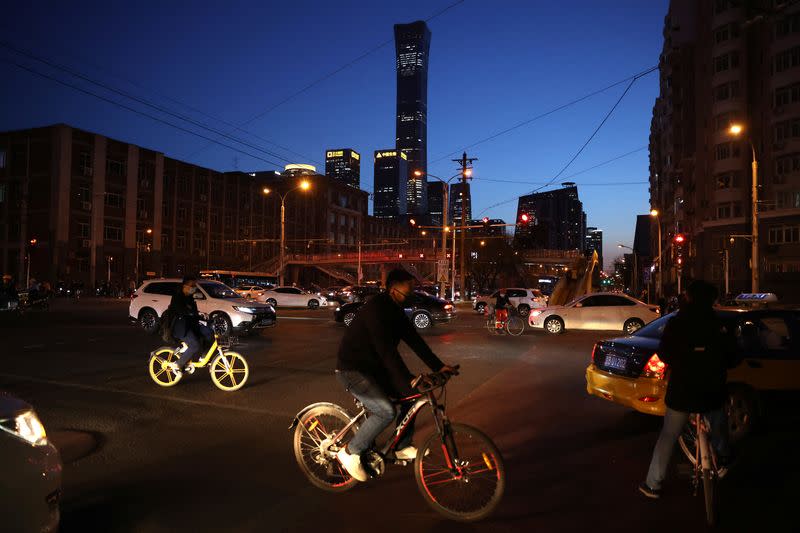 People ride bicycles of bike-sharing service on a street in Beijing’s Central Business District (CBD)