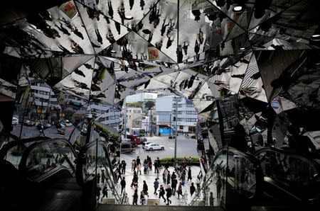 People are reflected in mirrors at an entrance to a department store in Tokyo, Japan, November 11, 2015. REUTERS/Toru Hanai/File Photo