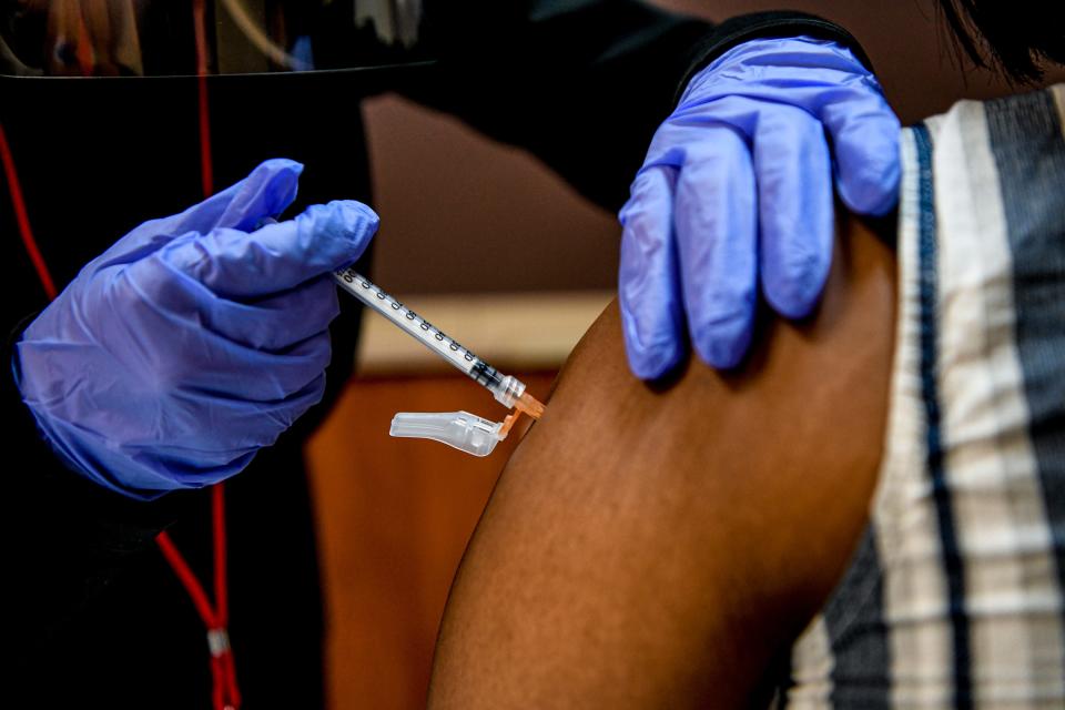 A health care worker administers the COVID-19 vaccine.