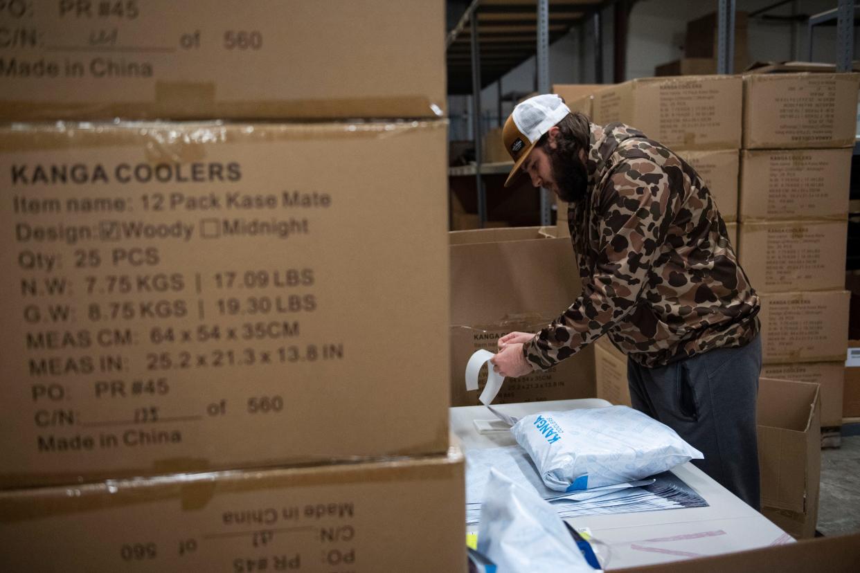 Ryan Miller, warehouse manager at Kanga Coolers, packs orders to be shipped in the warehouse in Greenville on Monday, Dec. 18, 2023.
