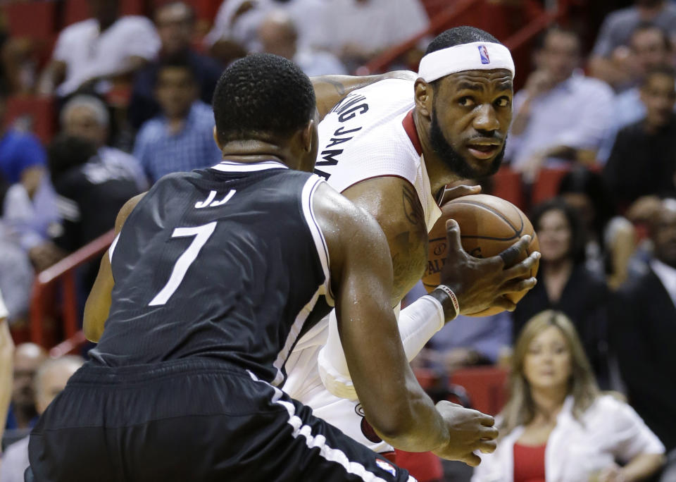 Miami Heat forward LeBron James, right, looks for an open teammate past Brooklyn Nets guard Joe Johnson (7) during the first half of an NBA basketball game, Wednesday, March 12, 2014, in Miami. (AP Photo/Wilfredo Lee)