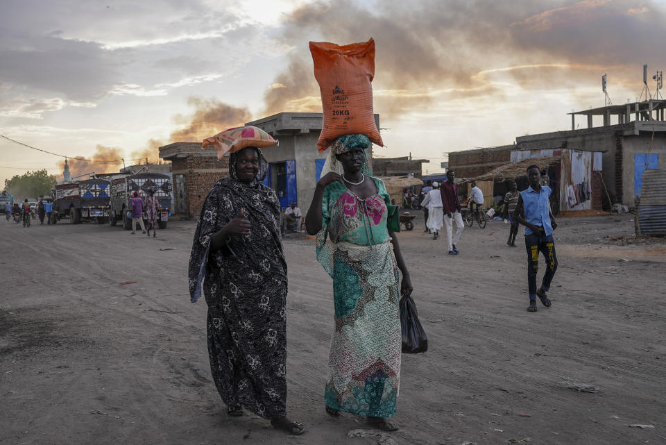 Two women walk down a street in Renk, South Sudan Tuesday, May 16, 2023. Tens of thousands of South Sudanese are flocking home from neighboring Sudan, which erupted in violence last month. (AP Photo/Sam Mednick)
