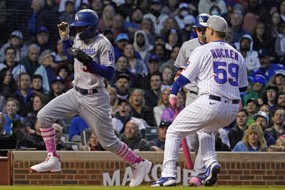 Los Angeles Dodgers' Mookie Betts, left, scores on a wild pitch by Chicago Cubs relief pitcher Michael Rucker (59) during the fifth inning of a baseball game in Chicago, Sunday, May 8, 2022. (AP Photo/Nam Y. Huh)