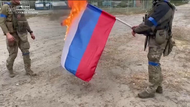 Soldados ucranianos queman una bandera rusa en Vovchansk, Ucrania.