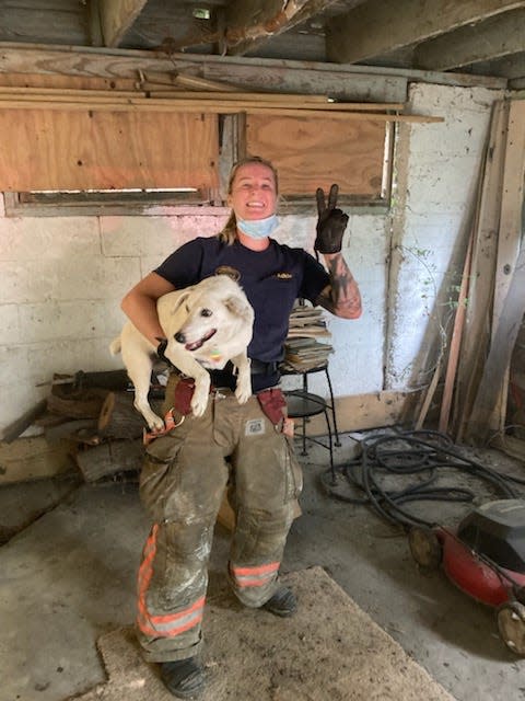 Firefighter Jenny Adkin of the Cincinnati Fire Department poses with the dog Gertie, who was trapped in between two concrete walls.