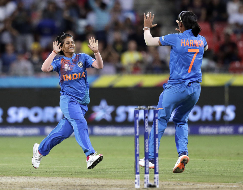 India's Poonam Yadav, left, celebrates with teammate Harmanpreet Kaur after taking the wicket of Australia's Jess Jonassen during the first game of the Women's T20 Cricket World Cup in Sydney, Friday, Feb. 21, 2020. (AP Photo/Rick Rycroft)