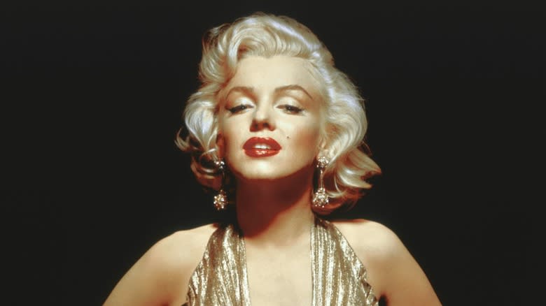 Marilyn Monroe in a gold dress black background