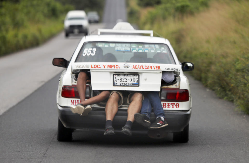 In this Nov. 3, 2018 photo, Central American migrants, part of the caravan hoping to reach the U.S. border, a ride on in the trunk of a taxi, in Acayucan, Veracruz state, Mexico. (AP Photo / Marco Ugarte)