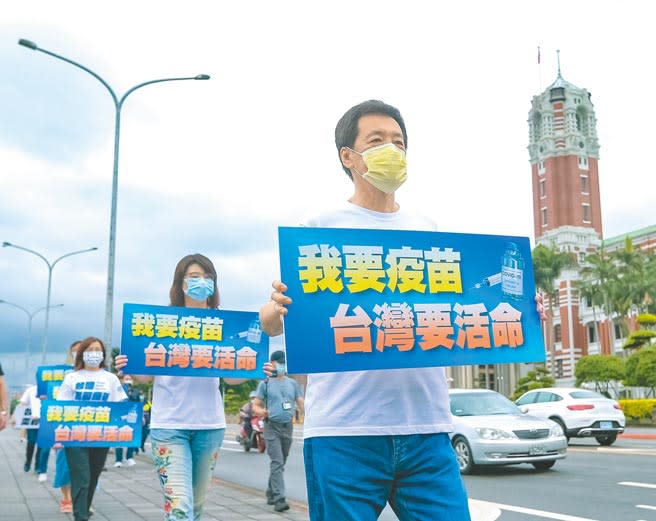 國民黨立法院黨團5日第二天舉行「我要疫苗，台灣要活命」活動，黨團總召費鴻泰（右）與同黨立委繞行總統府並高舉標語，呼籲蔡政府不要再擋疫苗。（羅永銘攝）