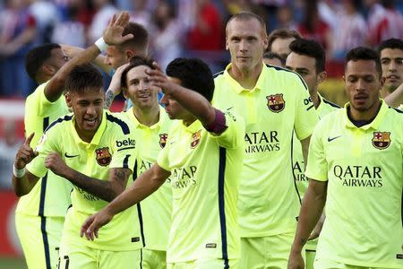 Barcelona players celebrate after winning the Spanish first division title following their soccer match against Atletico Madrid at at Vicente Calderon stadium in Madrid, Spain, May 17, 2015. REUTER/Juan Medina