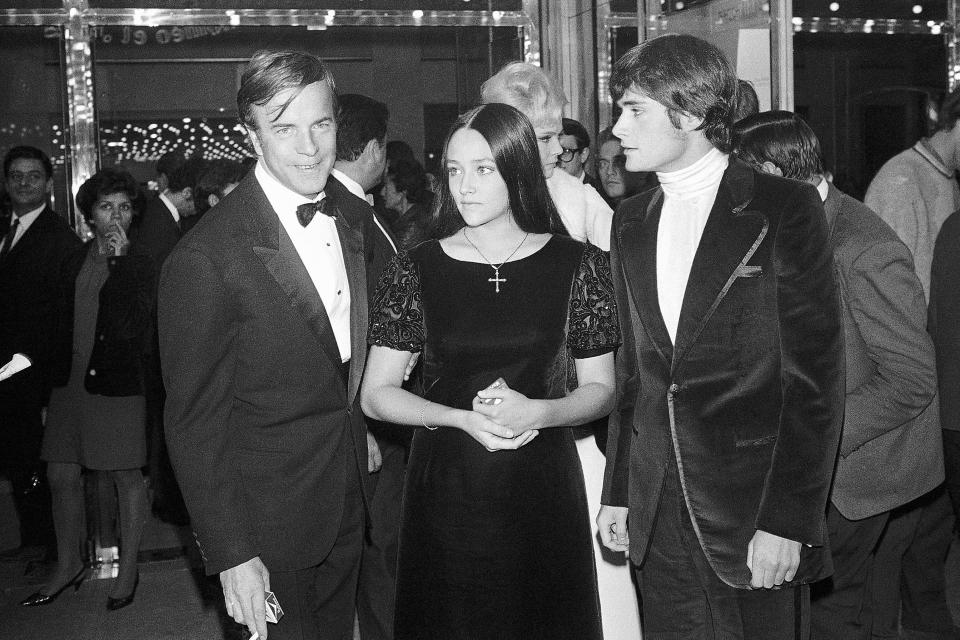 FILE - "Romeo and Juliette" movie director Franco Zeffirelli, left, actors Olivia Hussey, center, and Leonard Whiting are seen after the Parisian premiere of the film in Paris on Sept. 25, 1968. The two stars of 1968's “Romeo and Juliet” sued Paramount Pictures for more than $500 million on Tuesday, Jan. 3, 2023, over a nude scene in the film shot when they were teens. (AP Photo/Eustache Cardenas, File)