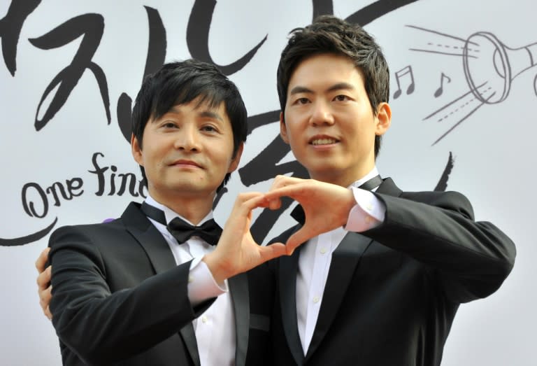 Film director Kim Jho Gwang-Soo (L) and his partner Kim Seung-Hwan pose during a press conference before their wedding in central Seoul on September 7, 2013