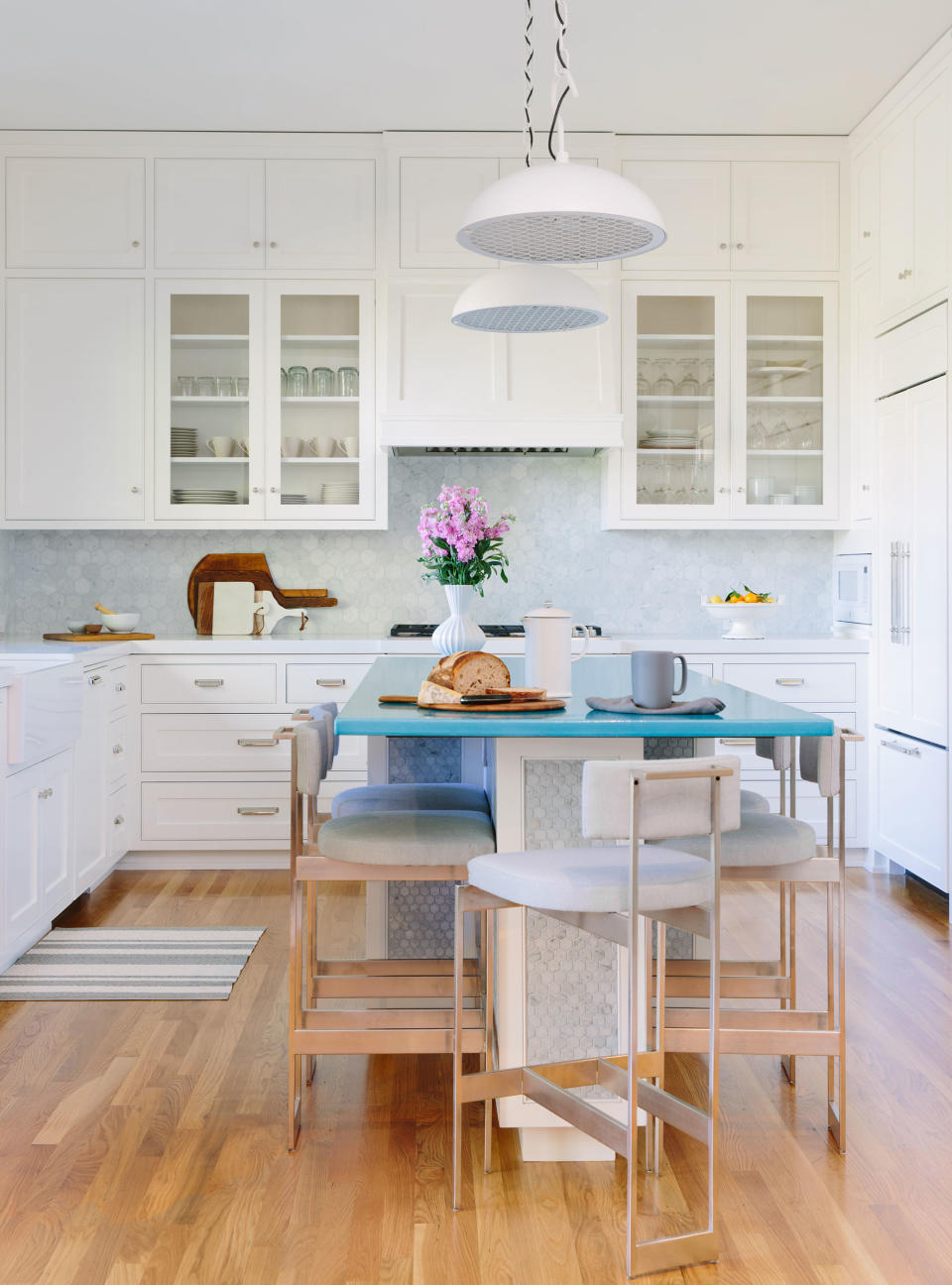 White kitchen with blue countertop and wood flooring