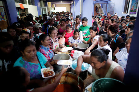 Volunteers serve food to Honduran migrants, part of a caravan trying to reach the U.S., at a church near the border with Mexico, in Tecun Uman, Guatemala October 19, 2018. REUTERS/Ueslei Marcelino