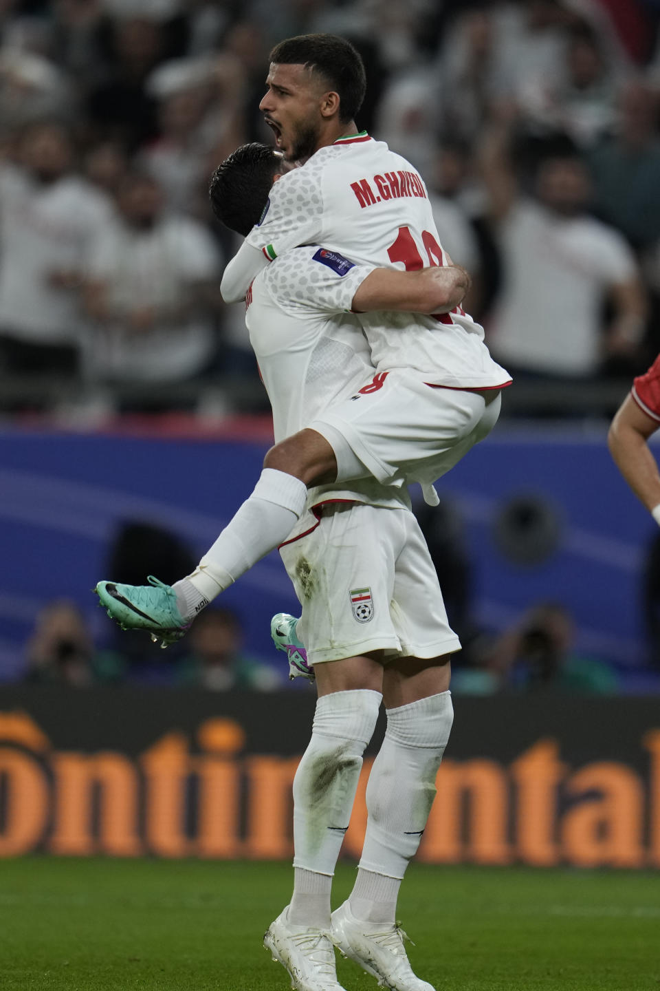 Iran's Mehdi Ghayedi, top, celebrates after scoring his side's third goal during the Asian Cup Group C soccer match between Iran and Palestine at the Education City Stadium in Al Rayyan, Qatar, Sunday, Jan. 14, 2024. (AP Photo/Aijaz Rahi)