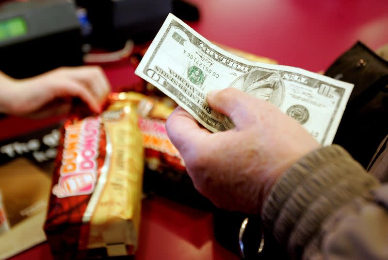 FILE PHOTO: A customer pays for two bags of coffee at a Dunkin' Donuts store in Tewksbury