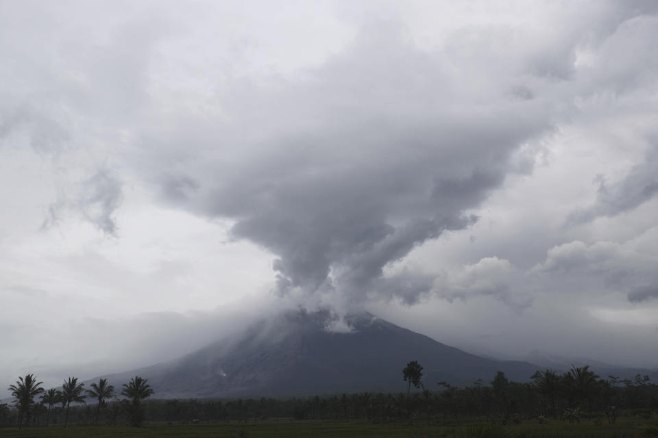 Mount Semeru releases volcanic materials during an eruption as seen from Lumajang district, East Java province, Indonesia, Monday, Dec. 6, 2021. The highest volcano on Java island spewed thick columns of ash into the sky in a sudden eruption Saturday triggered by heavy rains. Villages and nearby towns were blanketed and several hamlets buried under tons of mud from volcanic debris. (AP Photo/Trisnadi)