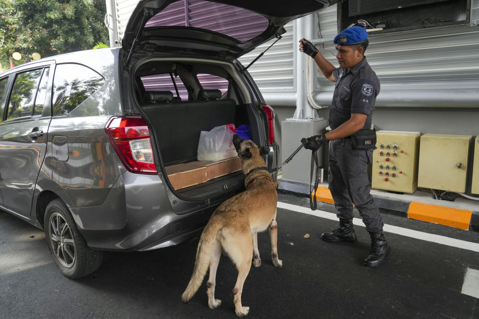 An Indonesian security officer with his dog checks a car ahead of the Association of Southeast Asian Nations (ASEAN) foreign ministers' meeting in Jakarta, Indonesia, Monday, July 10, 2023. Southeast Asia’s top diplomats gather for talks this week in Indonesia.(AP Photo/Tatan Syuflana)