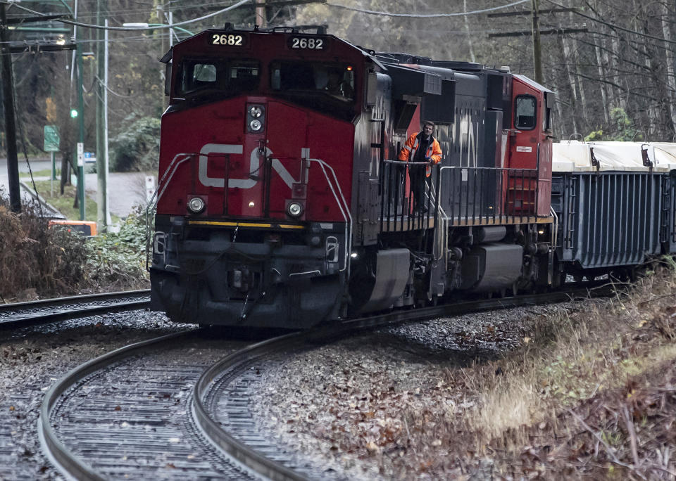 A Canadian National rail worker stands on an idle locomotive as protesters opposed to the Trans Mountain pipeline expansion block rail lines, in Burnaby, British Columbia, Friday, Nov. 27, 2020. Canadian National sweetened its offer to buy Kansas City Southern railroad Thursday, May 13, 2021, and derailed rival Canadian Pacific’s bid for the railroad that handles traffic in the United States and Mexico. (Darryl Dyck/The Canadian Press via AP)