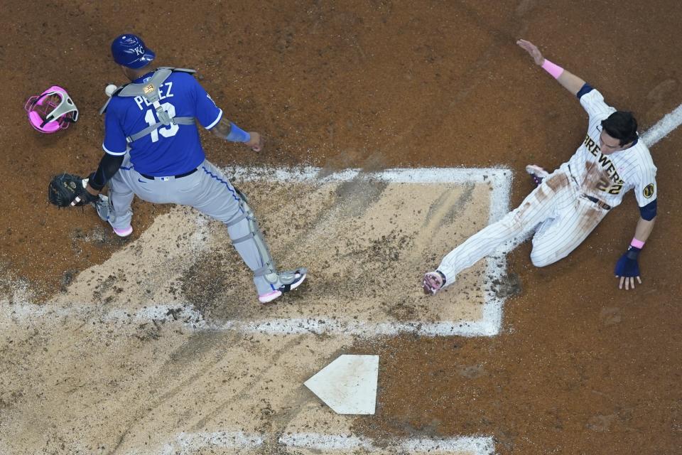 Milwaukee Brewers' Christian Yelich scores past Kansas City Royals catcher Salvador Perez during the third inning of a baseball game Sunday, May 14, 2023, in Milwaukee. (AP Photo/Morry Gash)