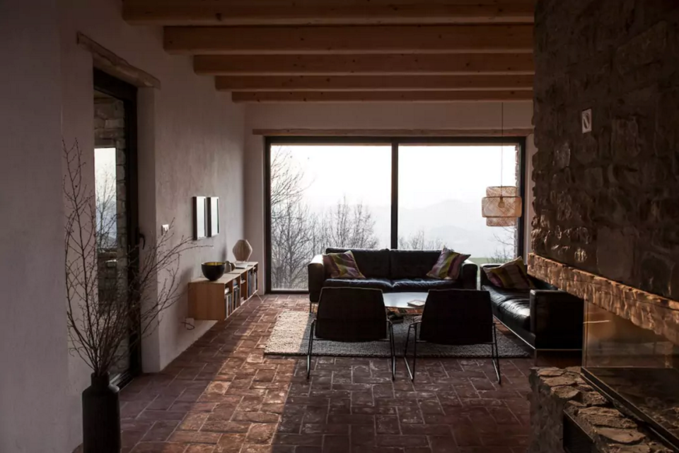 <p>The ultra-modern living room also boasts wood-beamed ceilings and spectacular views. (Airbnb) </p>