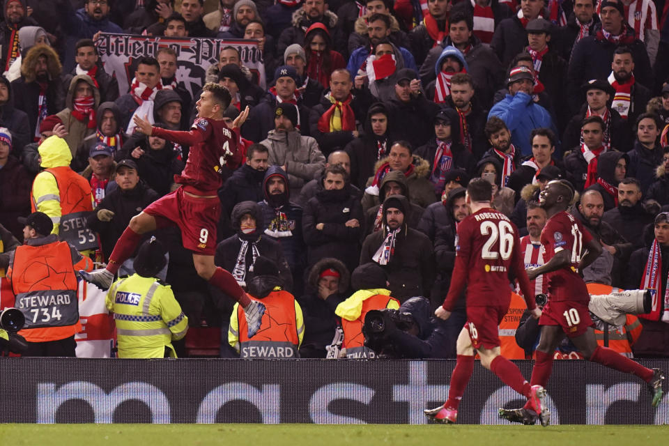 FILE - In this file photo taken on March 11, 2020, Liverpool's Roberto Firmino celebrates after scoring his side's second goal during a Champions League soccer match between Liverpool and Atletico Madrid at Anfield stadium in Liverpool, England. The Premier League trophy should have been in Liverpool’s hands by now. This week should have featured a victory parade through the streets of Liverpool. But the wait to end the 30-year title drought goes on. (AP Photo/Jon Super)