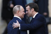 French President Emmanuel Macron, right, welcomes Russian President Vladimir Putin wave at the Elysee Palace Monday, Dec. 9, 2019 in Paris. A long-awaited summit in Paris is aiming to find a way to end the war in Ukraine, after five years and 14,000 lives lost in a conflict that has emboldened the Kremlin and reshaped European geopolitics. (AP Photo/Thibault Camus)