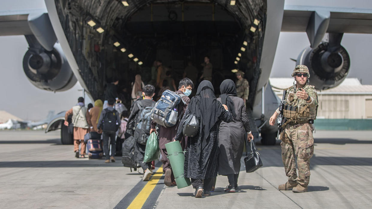 Families begin to board a U.S. Air Force Boeing C-17 Globemaster III during an evacuation at Hamid Karzai International Airport, Kabul, Afghanistan on August 23,2021. (Sgt Samuel Ruiz/W.S. marine Corps /EPA-EFE/Shutterstock)
