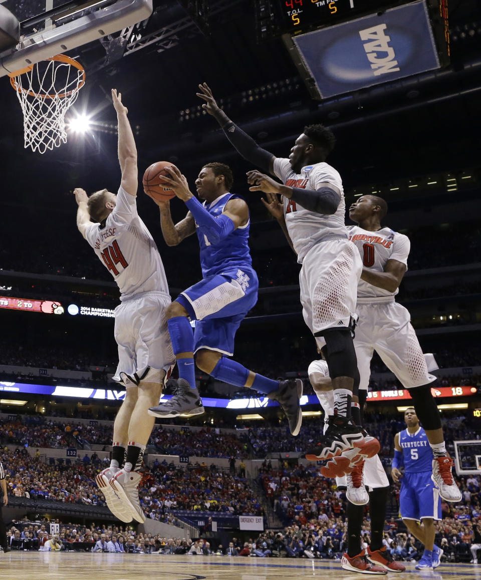 Kentucky's James Young goes up for a shot Louisville's Stephan Van Treese (44), Montrezl Harrell (24) and Terry Rozier (0) during the first half of an NCAA Midwest Regional semifinal college basketball tournament game against the Louisville Friday, March 28, 2014, in Indianapolis. (AP Photo/Michael Conroy)