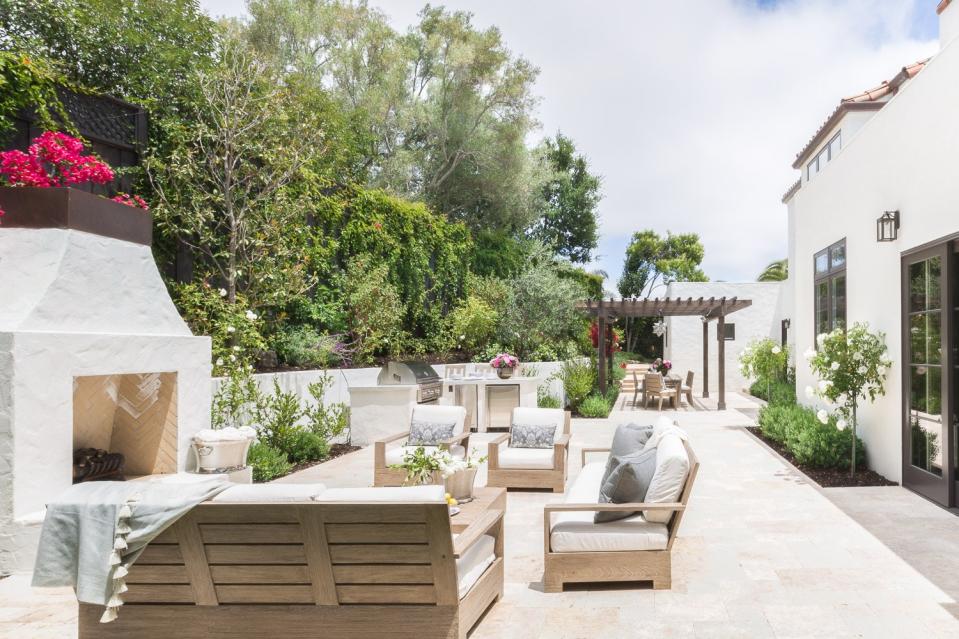 Amanda Barnes Interiors designed an outdoor kitchen that’s directly adjacent to the indoor one.