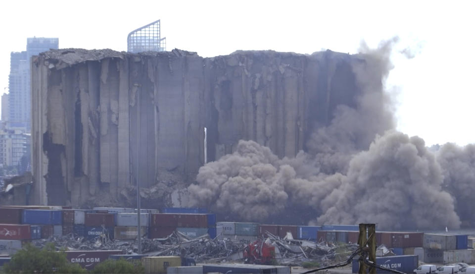 This frame grab from video shows part of the silos collapsing, in the port of Beirut, Lebanon, Sunday, July 31, 2022. A section of Beirut's massive port grain silos, shredded in the 2020 explosion, collapsed on Sunday after a weekslong fire triggered by grains that had fermented and ignited in the summer heat. (AP Photo)