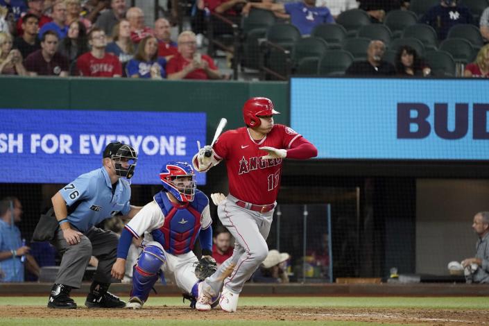Los Angeles Angels' Shohei Ohtani follows through on a ground out to second as Texas Rangers' Jose Trevino and umpire Mike Muchlinski looks on in the seventh inning of a baseball game in Arlington, Texas, Wednesday, Sept. 29, 2021. (AP Photo/Tony Gutierrez)