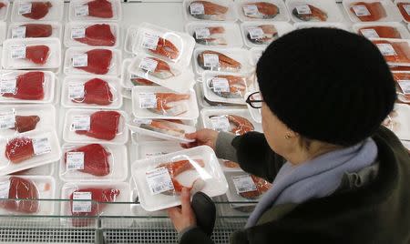 A customer picks fish fillet as she visits the fish department of a hypermarket of French grocery retailer Auchan in Moscow, January 15, 2015. REUTERS/Maxim Zmeyev