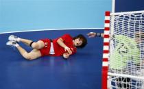 South Korea's Jo Hyobi falls after taking a shot against France in their women's handball Preliminaries Group B match at the Copper Box venue during the London 2012 Olympic Games August 3, 2012.