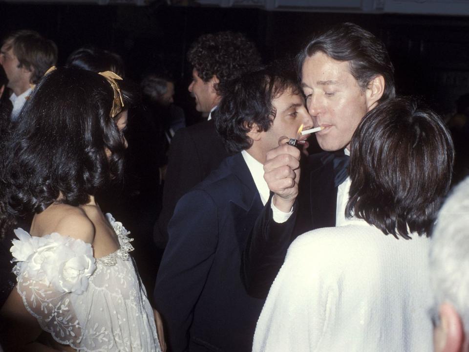 <p>Amid the craziness of the Studio 54 dance floor, the club's owner Steve Rubell, Bianca Jagger, and Liza Minnelli gather around American fashion designer, Halston, as he lights a cigarette. </p>