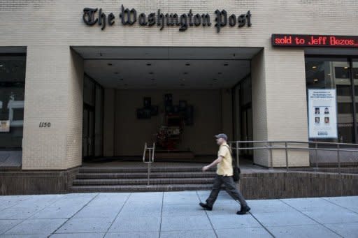 A man walks past The Washington Post building on August 5, 2013 in Washington, DC, after it was announced that Amazon.com founder and CEO Jeff Bezos had agreed to purchase the Post for US$250 million
