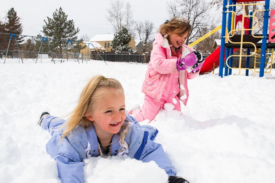 Kindergarteners Bailey Kimble, left, and Kira Hand play in the snow during recess at Shepardson Elementary School on Monday in Fort Collins.