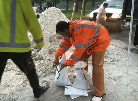 A city worker fills sandbags to help residents prepare for an expected tropical storm in Gulfport, Florida, U.S., October 31, 2016. REUTERS/Letitia Stein